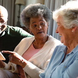 Friends looking at a tablet together and smiling
